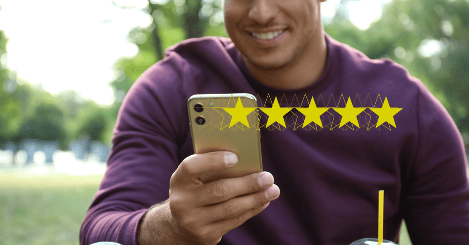 Smiling man with his phone leaving a 5-star review