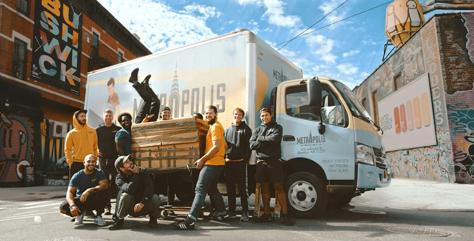 Move crew posing for a photo op in front of a moving truck
